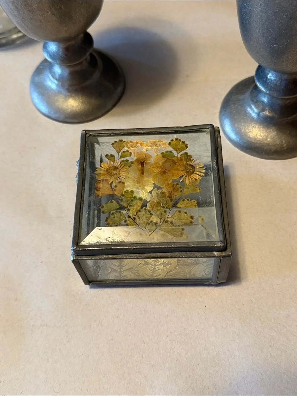 Vintage trinket box with metal edges and dried flowers on top. Mirror bottom.